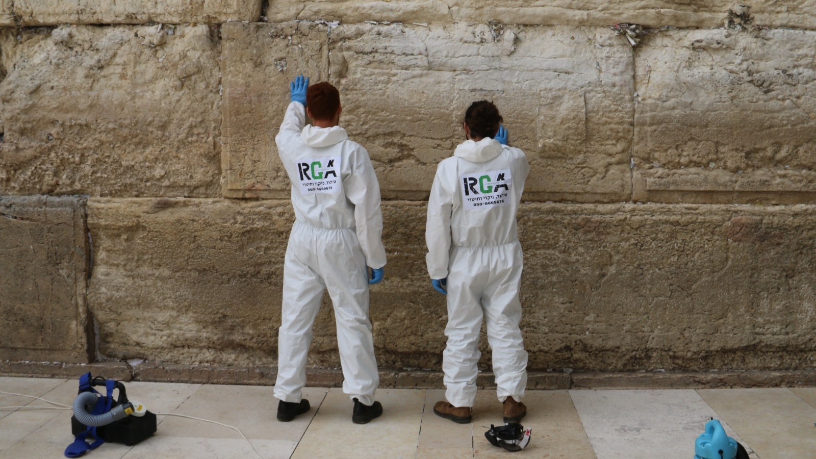 During the coronavirus pandemic, workers wore protective gear to clear notes from the Western Wall and sanitize its stones. Photo courtesy of The Western Wall Heritage Foundation