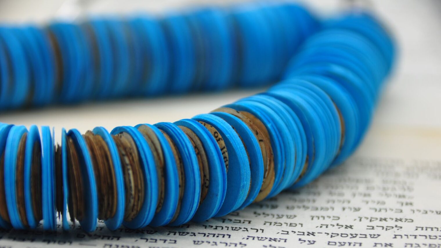 A piece of jewelry comprised of old books and colorful paper made by Israeli artist Hedva Klein. Photo: courtesy