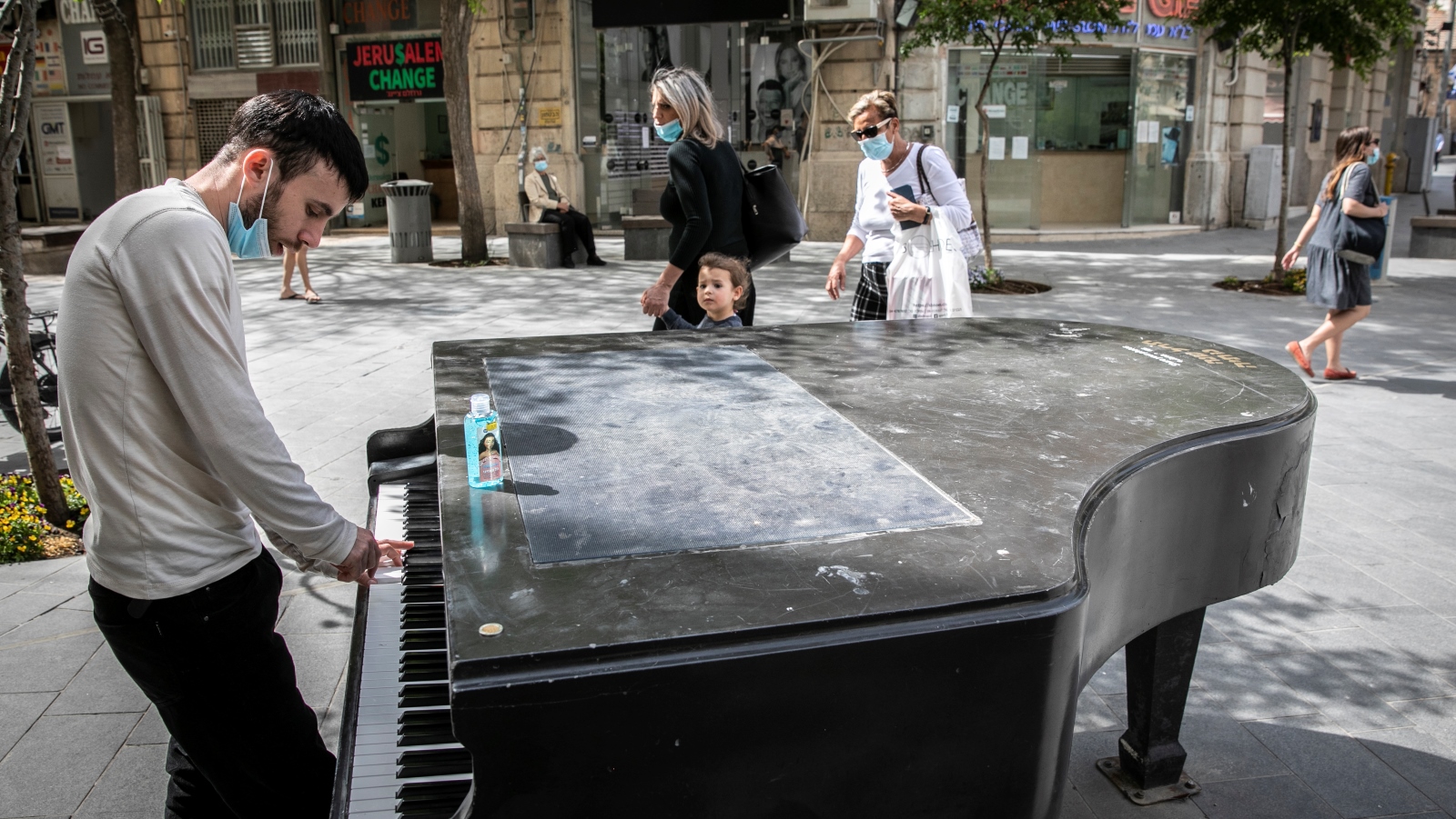 This man apparently used disinfectant gel on the keys of a public piano in downtown Jerusalem before beginning to play on May 3, 2020. Photo by Olivier Fitoussi/Flash90
