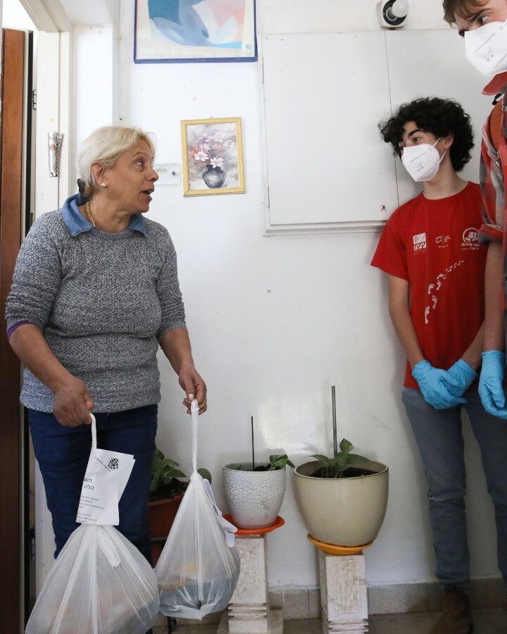 Volunteers bringing hot meals to a Jerusalem resident on March 29, 2020. Photo by Yossi Zamir/Flash90