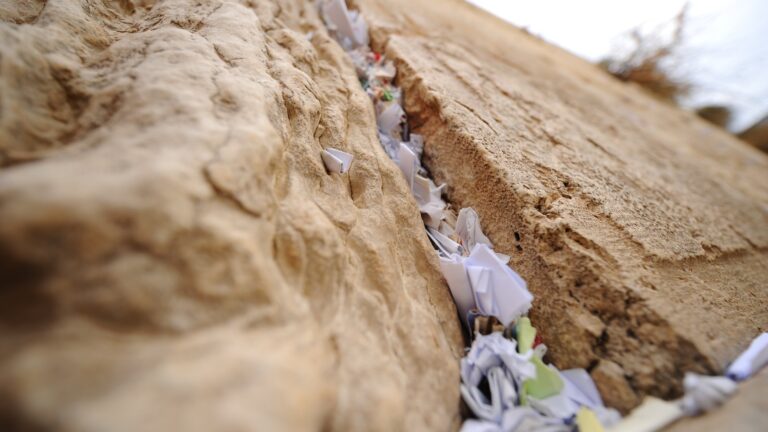 Handwritten notes placed between the ancient stones of the Western Wall in Jerusalem. Photo by Mendy Hechtman/FLASH90