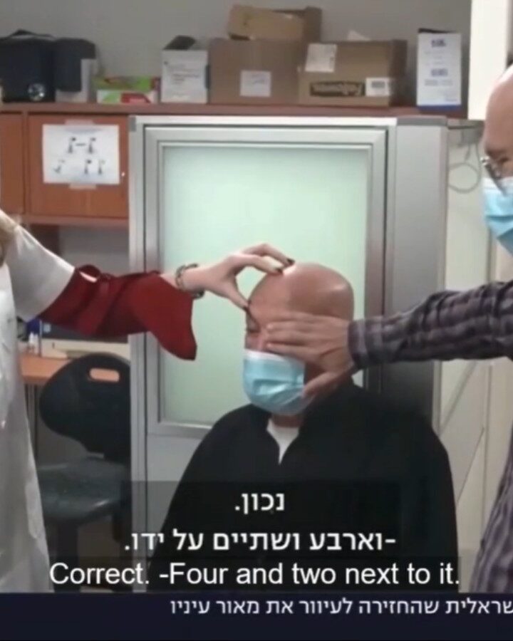 Jamal Furani reading a vision chart a day after receiving the KPro artificial cornea from CorNeat, surrounded by his surgeon, Dr. Irit Bahar, CorNeat cofounder Dr. Gilad Litvin and Furaniâ€™s daughter Khulud. Screenshot from Channel 13