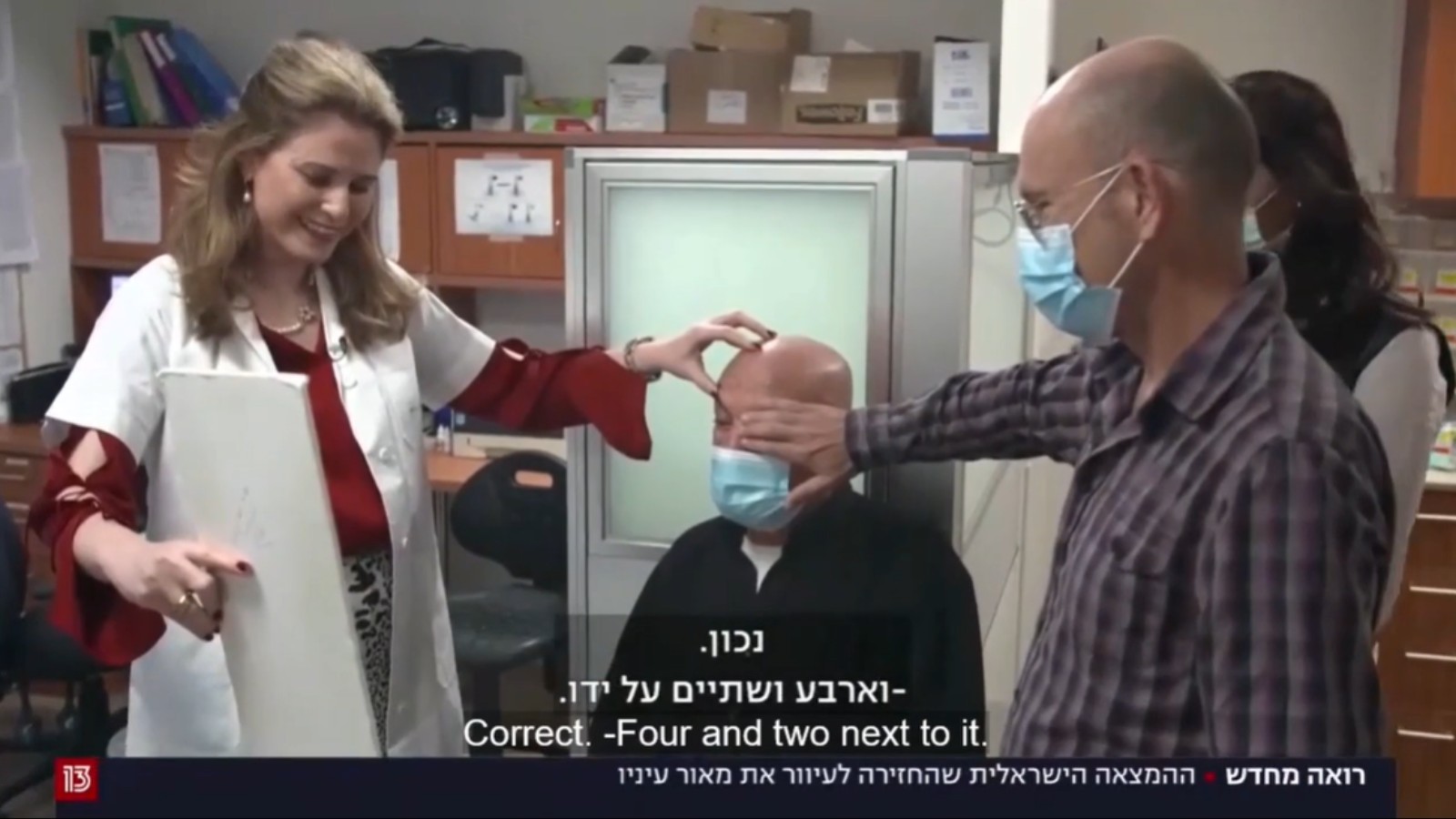 Jamal Furani reading a vision chart a day after receiving the KPro artificial cornea from CorNeat, surrounded by his surgeon, Dr. Irit Bahar, CorNeat cofounder Dr. Gilad Litvin and Furani’s daughter Khulud. Screenshot from Channel 13
