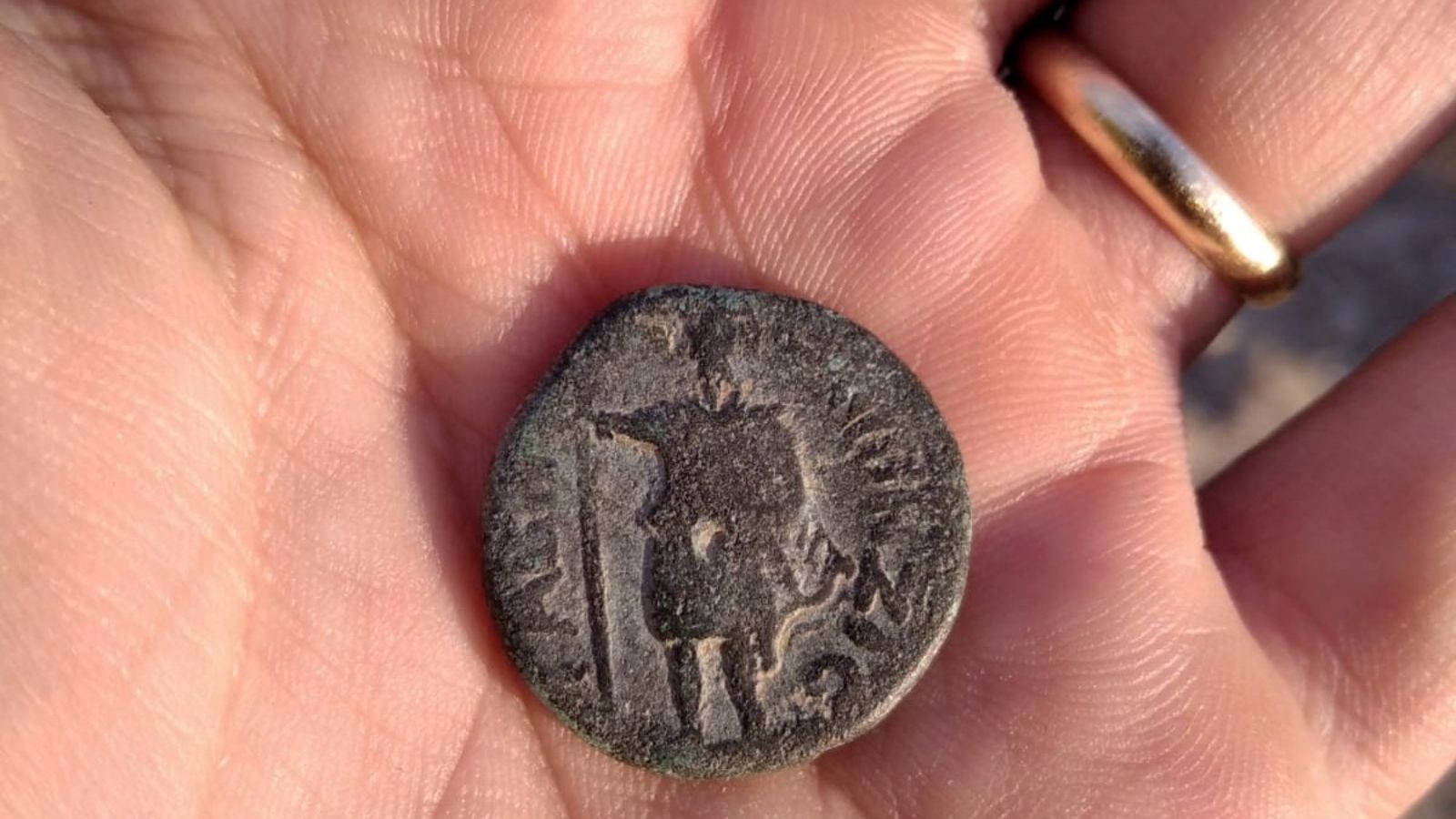 The ancient coin unearthed by an Israeli soldier depicting the Syrian moon god Men. Photo by Nir Distelfeld/Israel Antiquities Authority