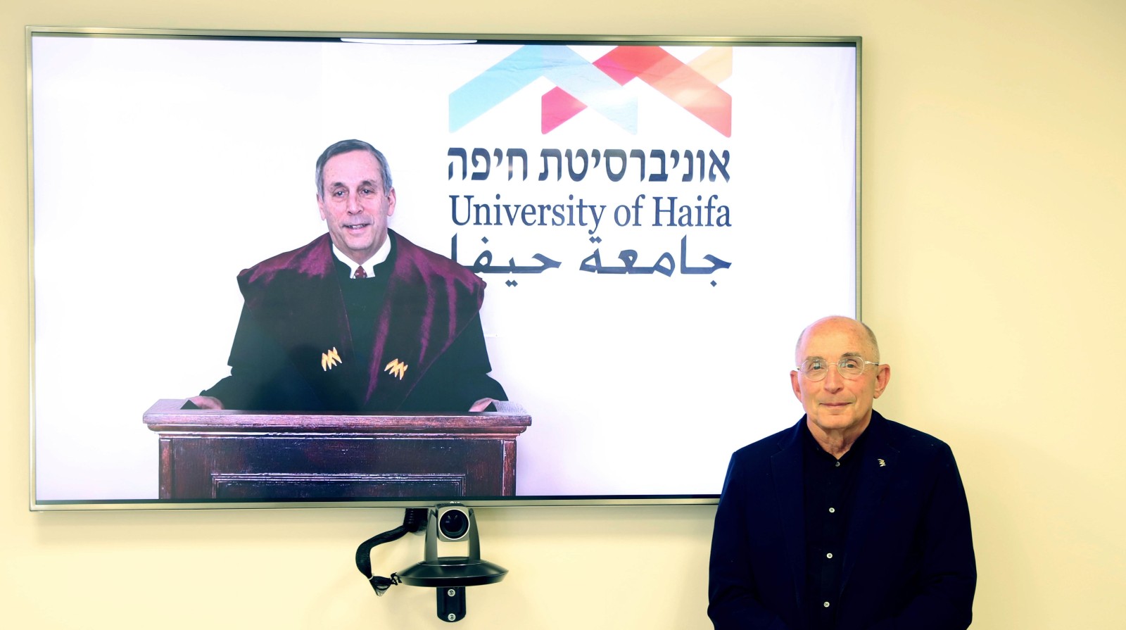 Harvard President Lawrence Bacow receiving an honorary doctorate from the University of Haifa President Ron Robin. Photo courtesy of University of Haifa
