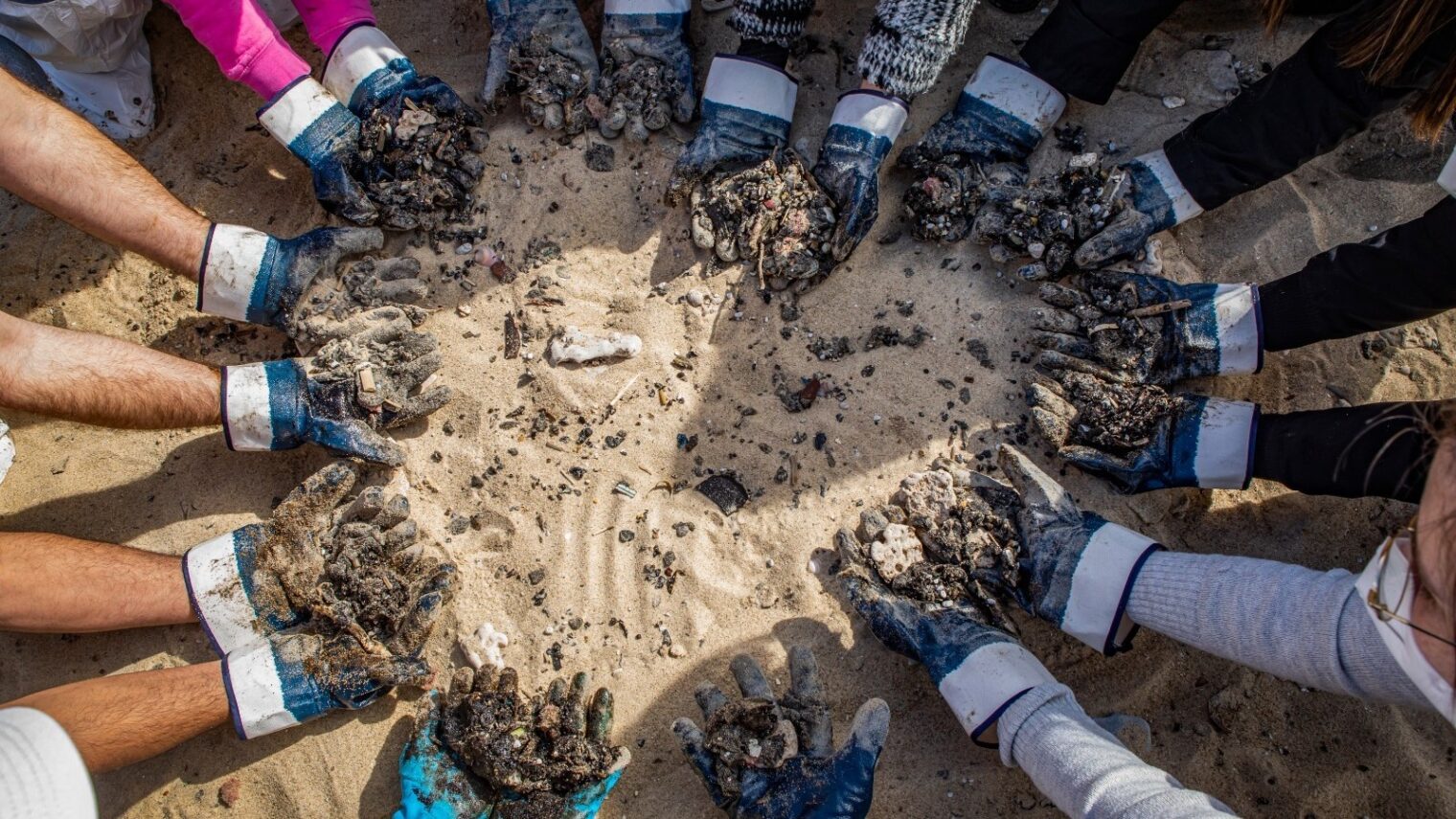 Photo of volunteers cleaning tar from Ga ’ash Beach by Dafna Ben Nun Photography