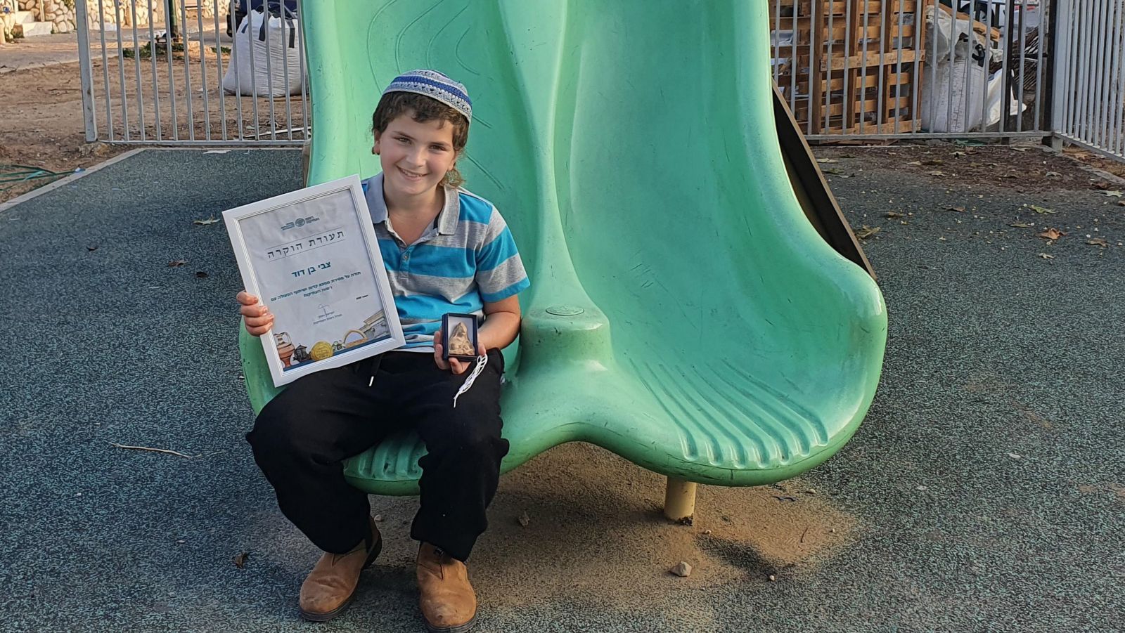 11-year-old Zvi Ben-David receives a certificate of appreciation for good citizenship for turning in his ancient figurine find. Photo by Oren Shmueli/Israel Antiquities Authority