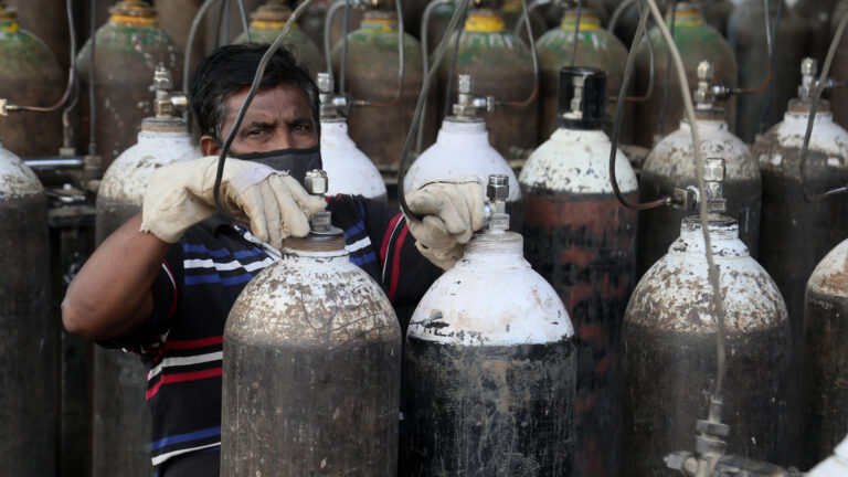 With oxygen in short supply in India, a worker refills medical oxygen cannisters for treatment of Covid-19 patients in New Delhi. Photo by Shutterstock