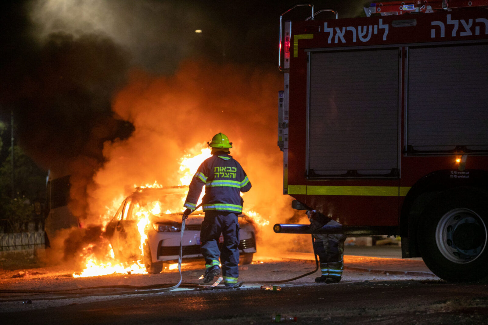 Putting out a fire after riots in the city of Lod on May 12, 2021. Photo by Yossi Aloni/Flash90