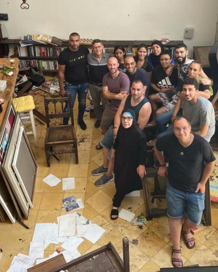 Evan Fallenberg (back row, second from left) and Micha Fallenberg (in front of his father) with staff of Arabesque after it was destroyed by a mob. Photo courtesy of Evan Fallenberg