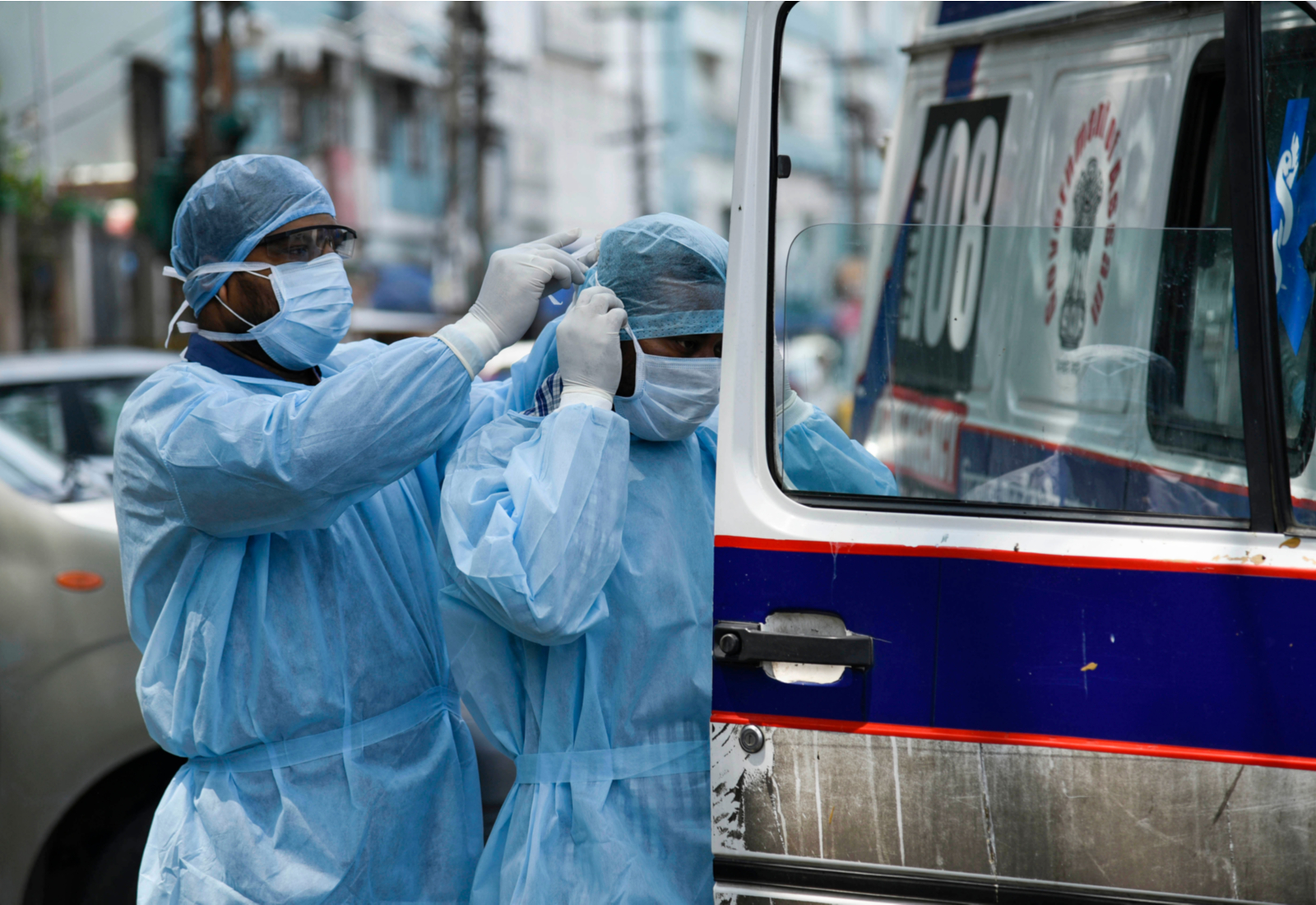 Health workers suit up before they transport people to hospital for testing in Guwahati in the northeastern Indian state of Assam. Photo by Talukdar David via Shutterstock.com 