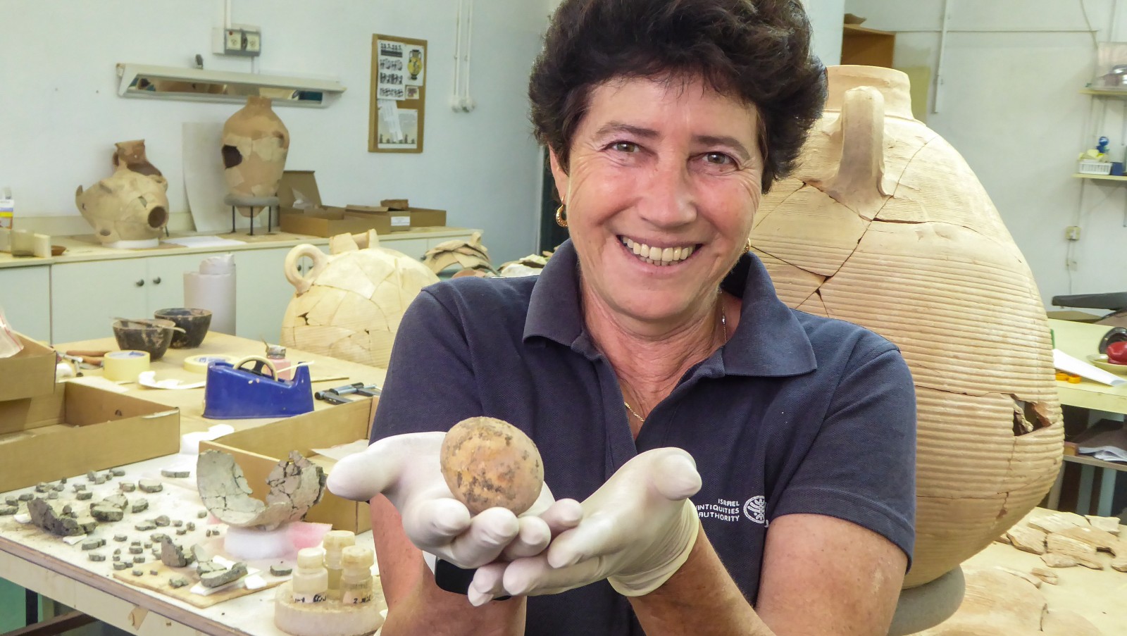 Israel Antiquities Authority archaeologist Alla Nagorsky with the ancient egg. 
Photo by Assaf Peretz/Israel Antiquities Authority
