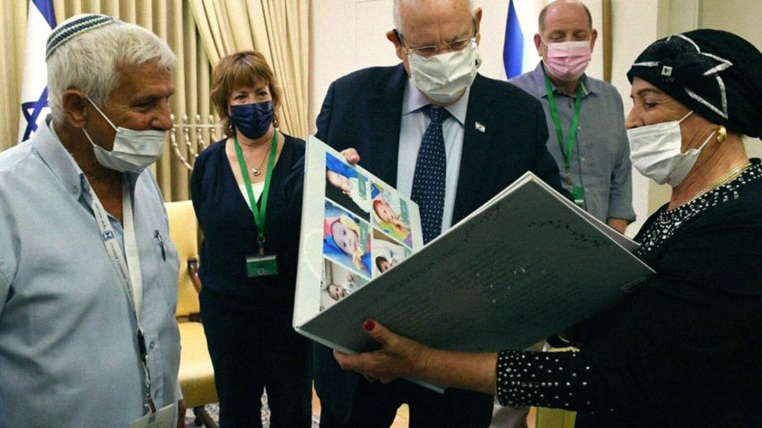 Angel Alon and husband Shlomo showing President Reuven Rivlin one of the albums she made for a foster child. Photo courtesy of Summit Institute