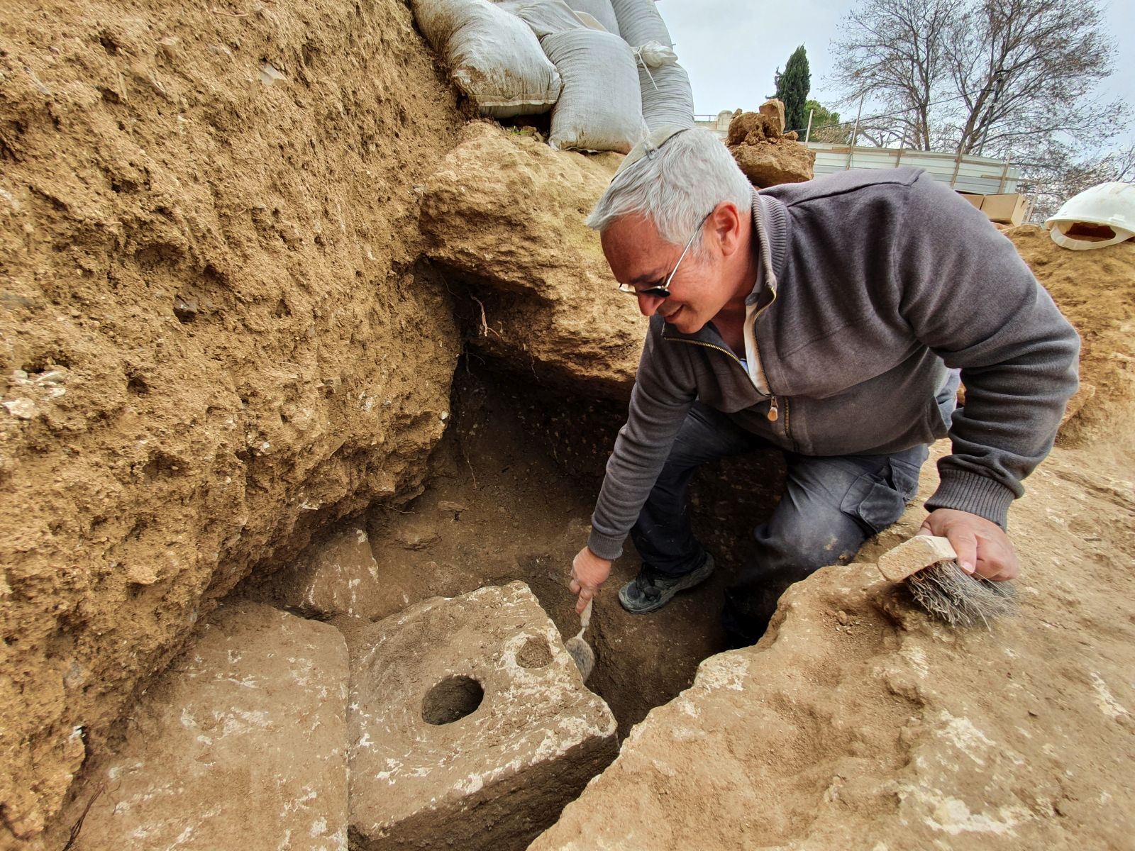 Archeologist Yaakov Billig of the Israel Antiquities Authority next to the ancient toilet in Jerusalem. Photo by Yoli Schwartz/IAA