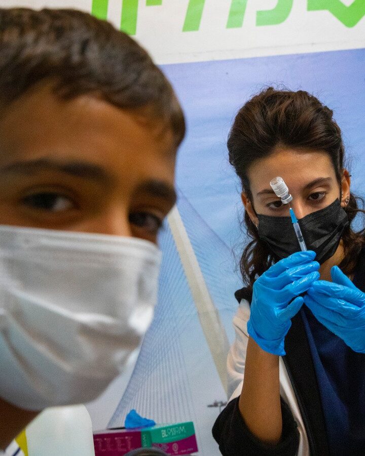 An Israeli adolescent receiving a Covid-19 vaccine at a Clalit Health Services Center in Jerusalem. Photo by Olivier Fitoussi/Flash90