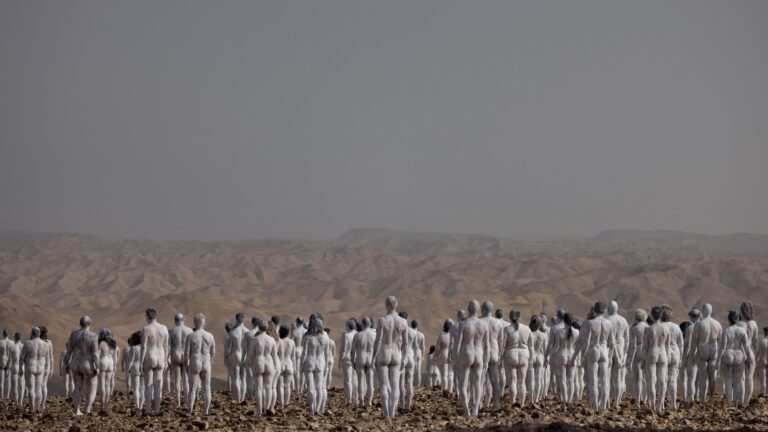 People painted in white pose for a group picture by art photographer Spencer Tunick and his team, outside Arad, October 17, 2021. Photo by Yonatan Sindel/Flash90