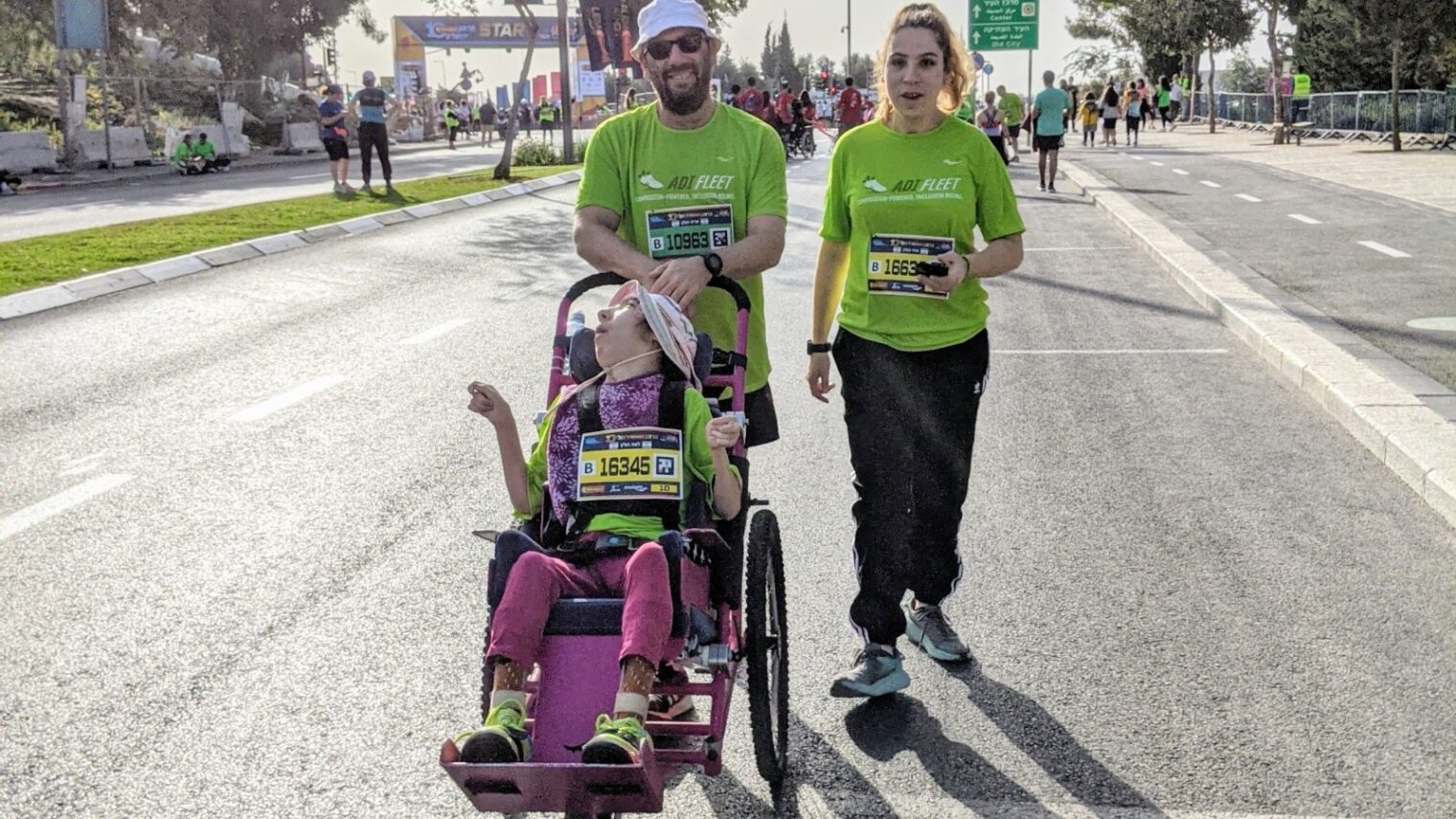 Aryeh Holtz at the International Jerusalem Marathon with twin daughters Miri and Leah. He built Leah’s running stroller from scratch. Photo courtesy of ADI