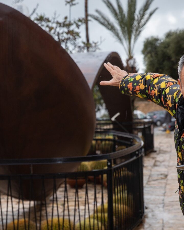 Mystifier Uri Geller next to a giant bent spoon outside his museum in Jaffa. Photo by Hadas Parush/Flash90