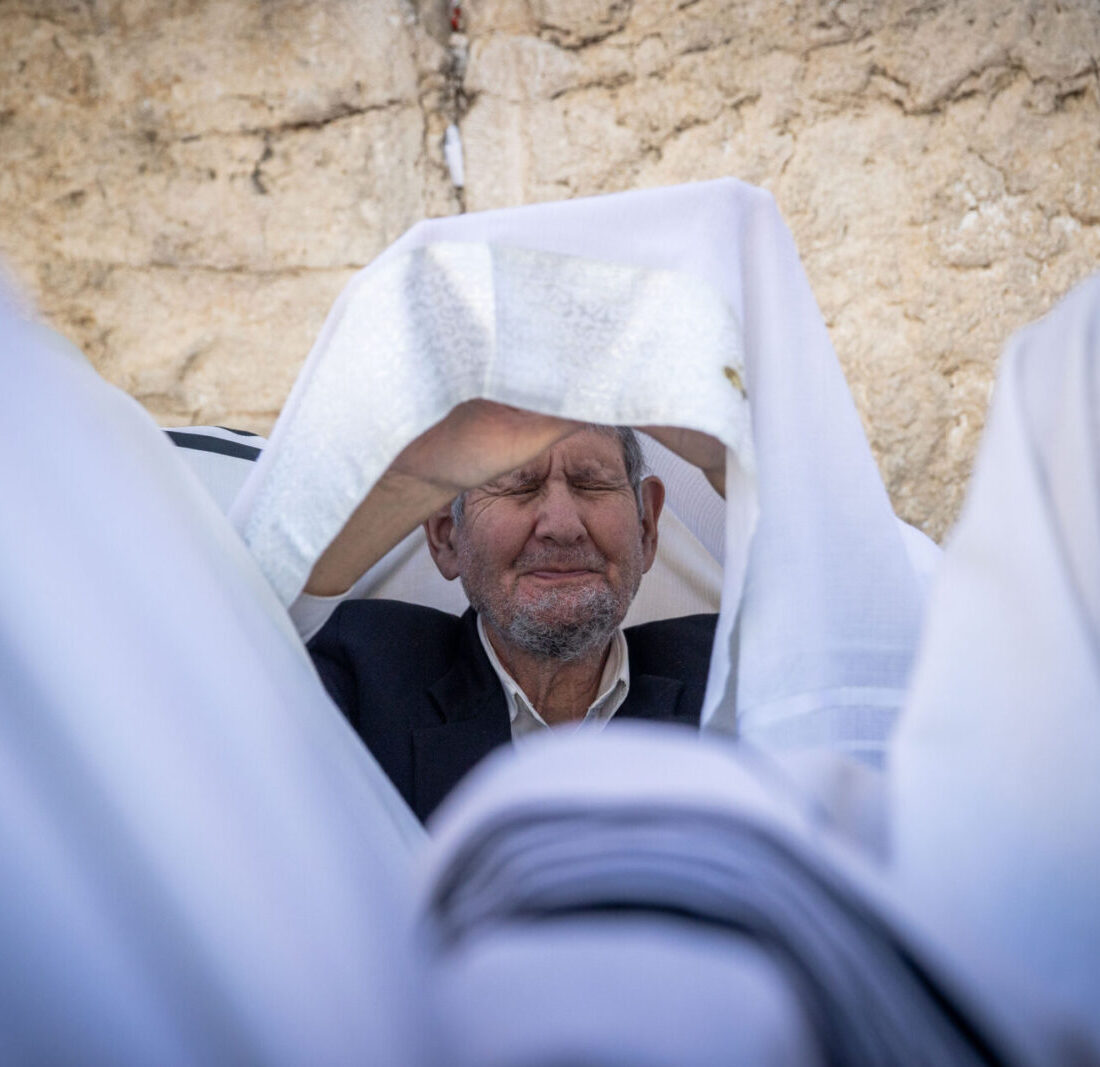 Jewish worshippers cover themselves with prayer shawls as they pray in front of the Western Wall, Judaism's holiest prayer site, in Jerusalem's Old City, during the Cohen Benediction priestly blessing at the Jewish holiday of Passover on March 30, 2021. Photo by Yonatan Sindel/Flash90