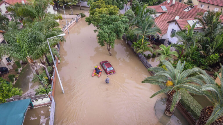 A fire fighter on a boat rescues people stuck on a flooded street after heavy rains in the southern Israeli city of Ashkelon. Photo by Edi Israel/Flash90