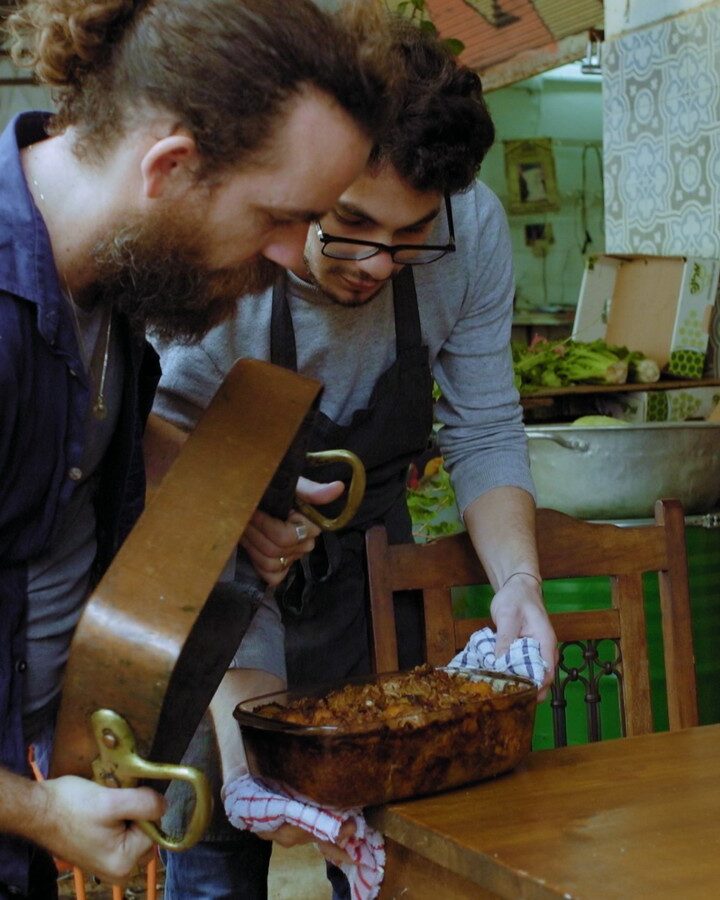 Chefs Ilan Ferron and Osama Dalal prepare to flip octopus maqluba in a scene from “Breaking Bread.” Photo courtesy of Cohen Media Group