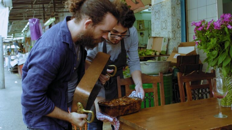Chefs Ilan Ferron and Osama Dalal prepare to flip octopus maqluba in a scene from “Breaking Bread.” Photo courtesy of Cohen Media Group