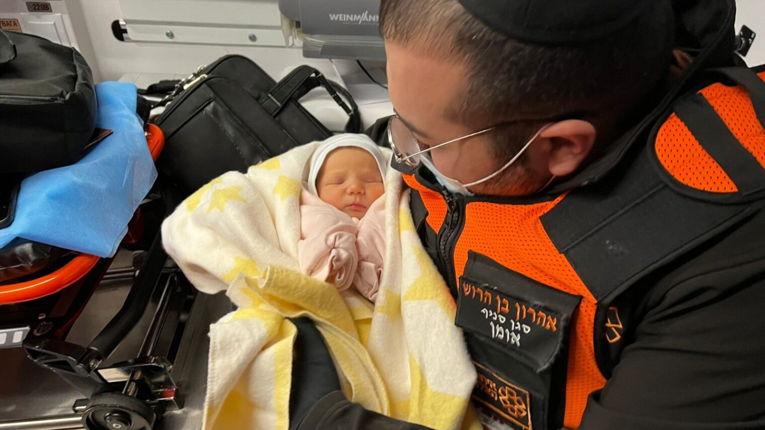 Aharon Ben Harush, United Hatzalah’s deputy commander of the relief mission to the Ukrainian-Moldovan border, in an ambulance with one of the Israeli newborns he helped rescue from war-torn Kyiv. Photo courtesy of United Hatzalah 