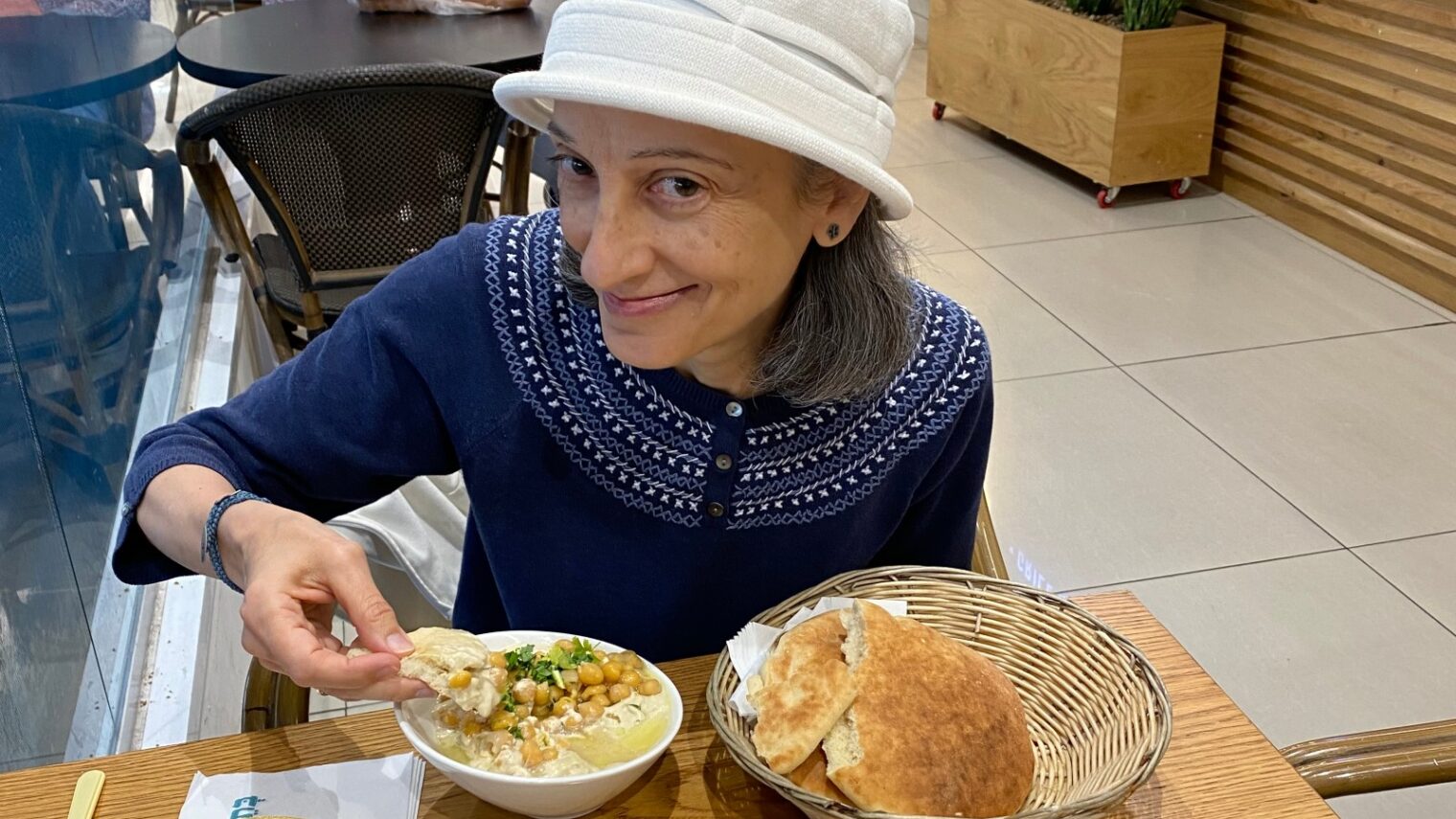 ISRAEL21c’s Abigail Klein Leichman enjoying authentic hummus at Bahadunas Hummus Bar. Photo by Barbara Casden 