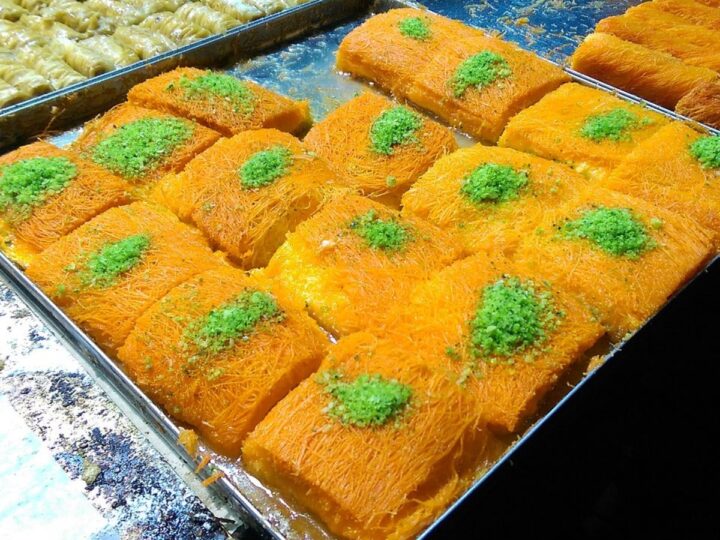 Tray with knafeh topped with shredded pistachio at Machane Yehuda Market, Jerusalem. Photo by Maor X via Wikimedia Commons