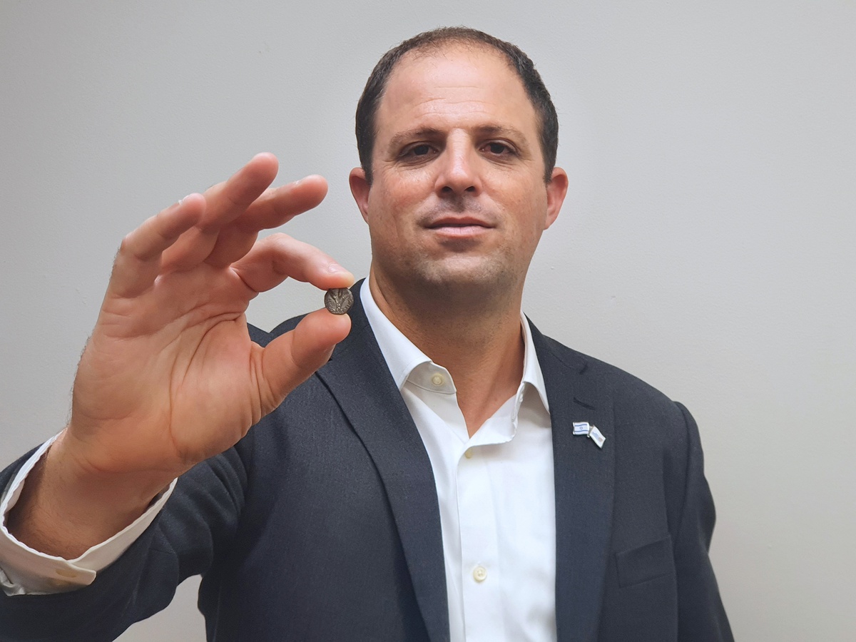 Ilan Hadad, Inspector in charge of commerce at the Israel Antiquities Authority, with the rare coin. Photo by Miri Bar, Israel Antiquities Authority
