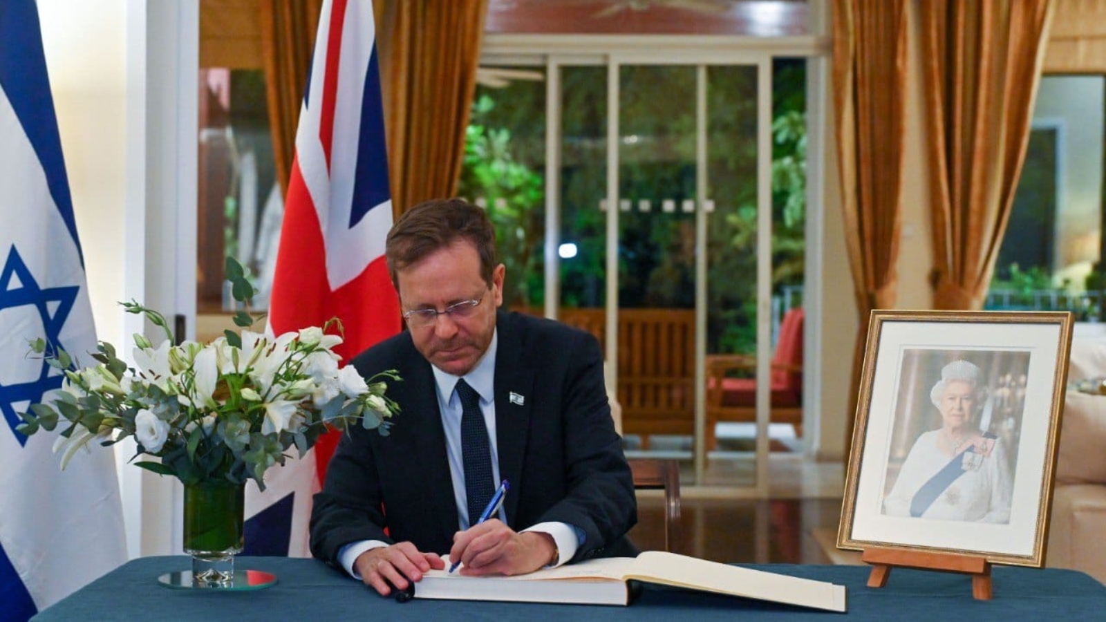 President Isaac Herzog signs the condolence book for Queen Elizabeth II at the British ambassador's residence in Israel. Photo by Koby Gideon/GPO