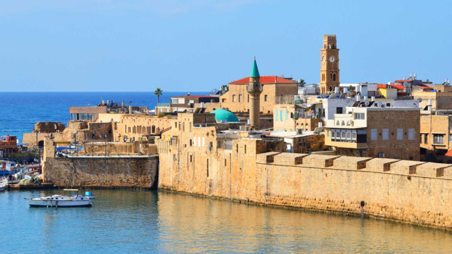 A view of Akkoâ€™s harbor, walls and houses of worship. Photo by Alex7370 via Shutterstock.com