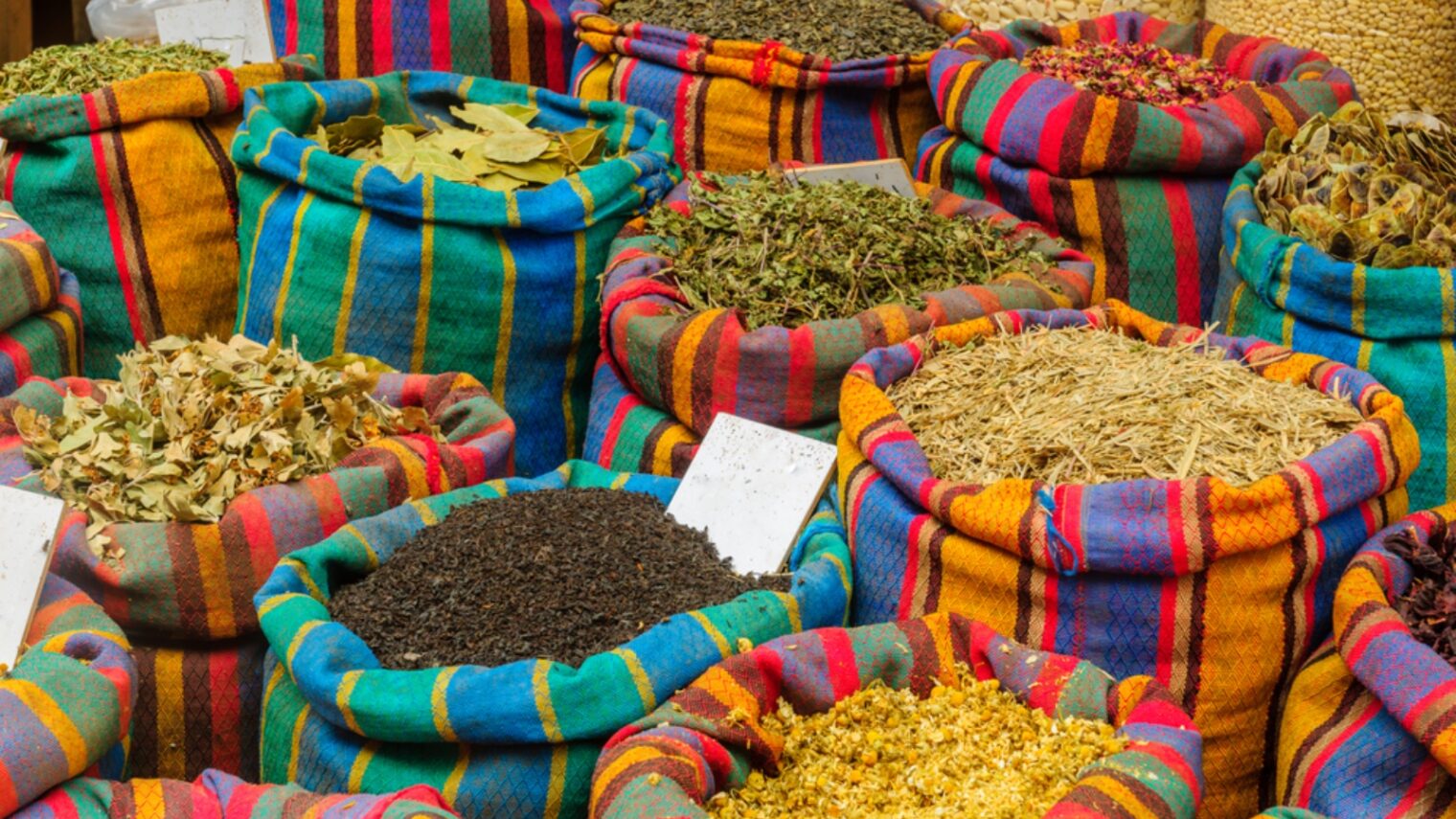 Spices in colorful sacks on sale in the market in Acre (Akko). Photo by RnDmS via Shutterstock.com