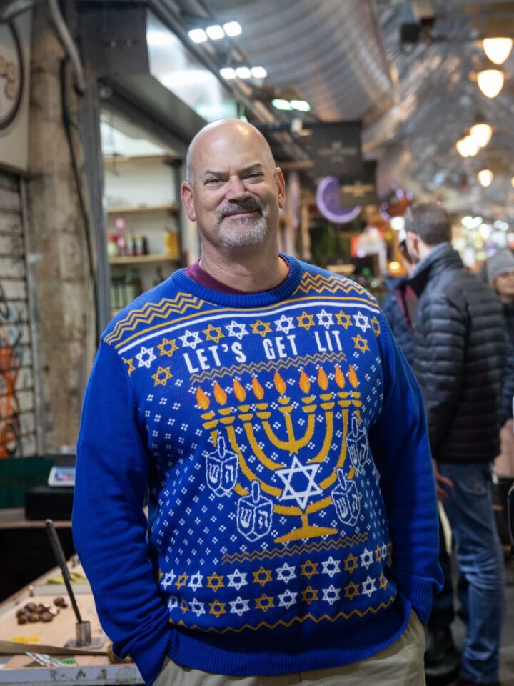An American Jewish man wears a Hanukkah sweater during the Jewish holiday of Hanukkah, at Machane Yehuda Market in Jerusalem, December 25, 2019. Photo by Hadas Parush/Flash90