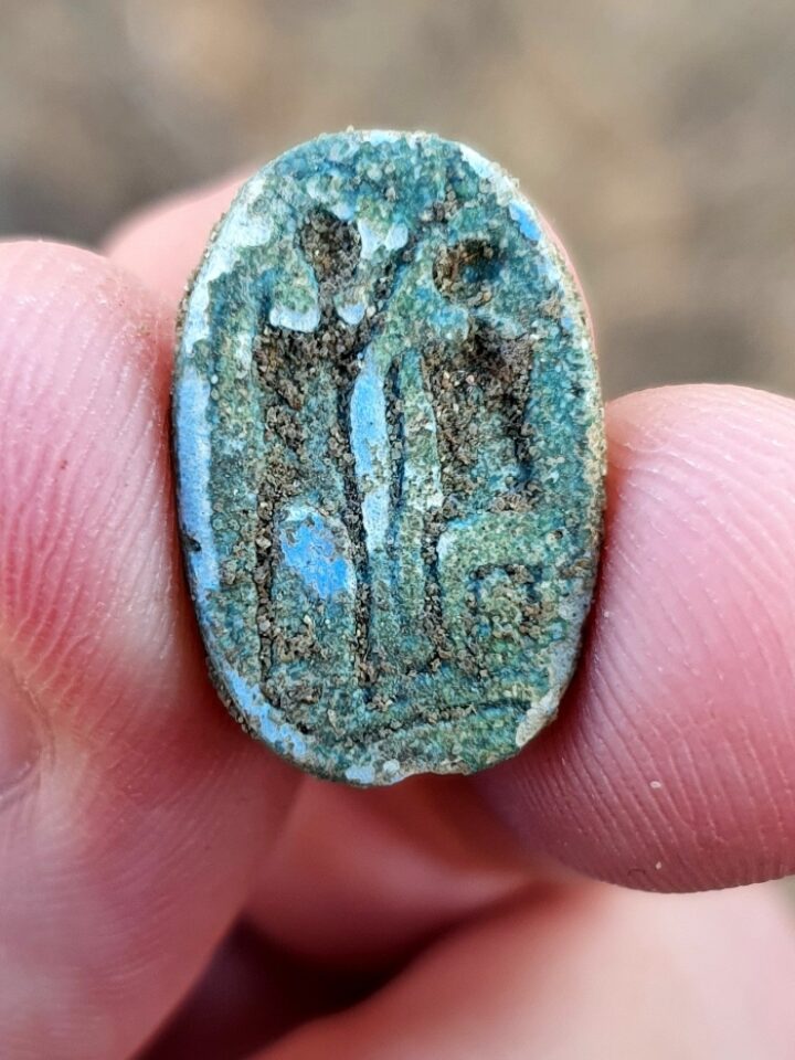 The scarab, showing a seated figure on the right and a standing figure with a raised arm on the left, possibly symbolizing the imparting of authority. Photo by Gilad Stern/Israel Antiquities Authority