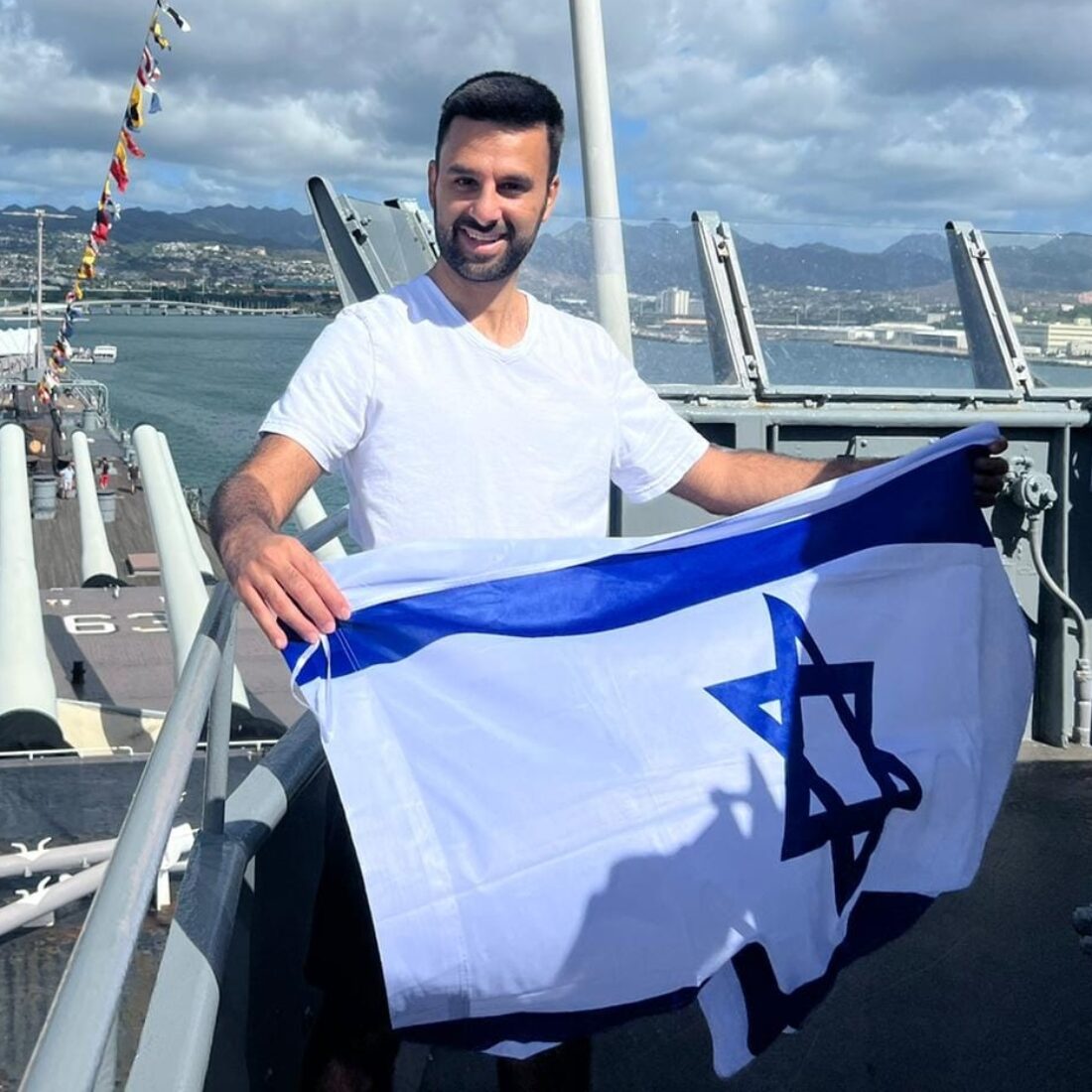 Yoseph Haddad waving the Israeli flag at Pearl Harbor in Hawaii. Photo courtesy of Yoseph Haddad