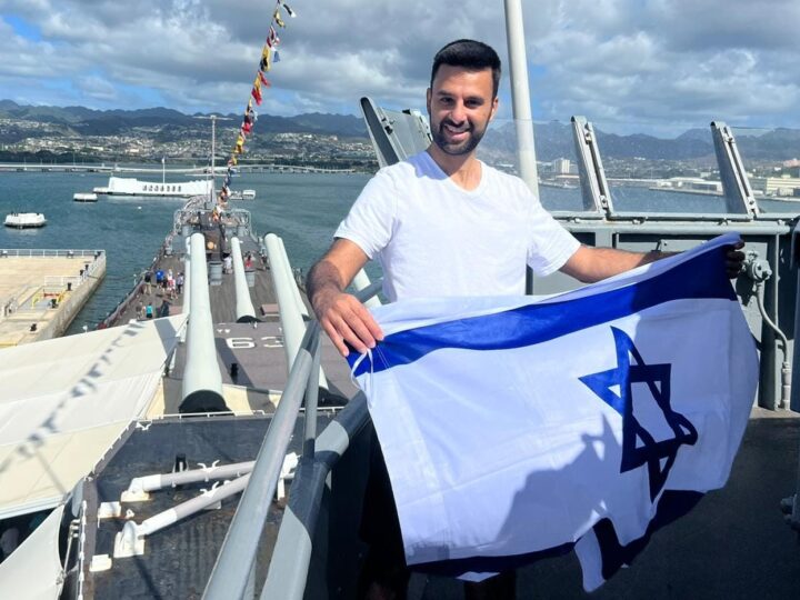 Yoseph Haddad waving the Israeli flag at Pearl Harbor in Hawaii. Photo courtesy of Yoseph Haddad