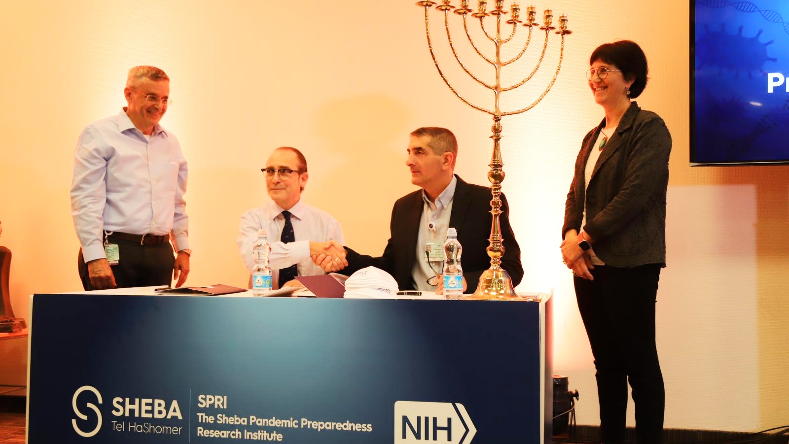 Dr. Daniel Douek from the NIH and Sheba Medical Center CEO Prof. Yitshak Kreiss signing a memorandum of understanding establishing the Sheba Pandemic Research Institute, December 22, 2022, with Prof. Dror Harats, far left, chair of R&D at Sheba, and Dr. Gili Regev-Yochay, director of the new institute, looking on. Photo courtesy of Sheba Medical Center