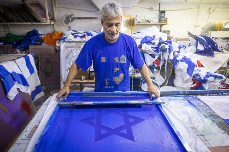 A Bermanâ€™s Flag employee pouring dye for the blue portions of the Israeli flag. Photo by Yonatan Sindel/Flash90