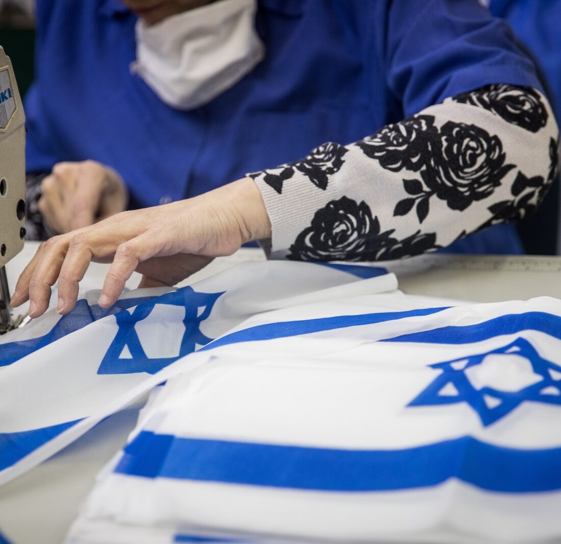 Workers making Israeli flags at Berman's Flags in Jerusalem on April 27, 2022, prior to Israeli Independence day. Photo by Yonatan Sindel/Flash90