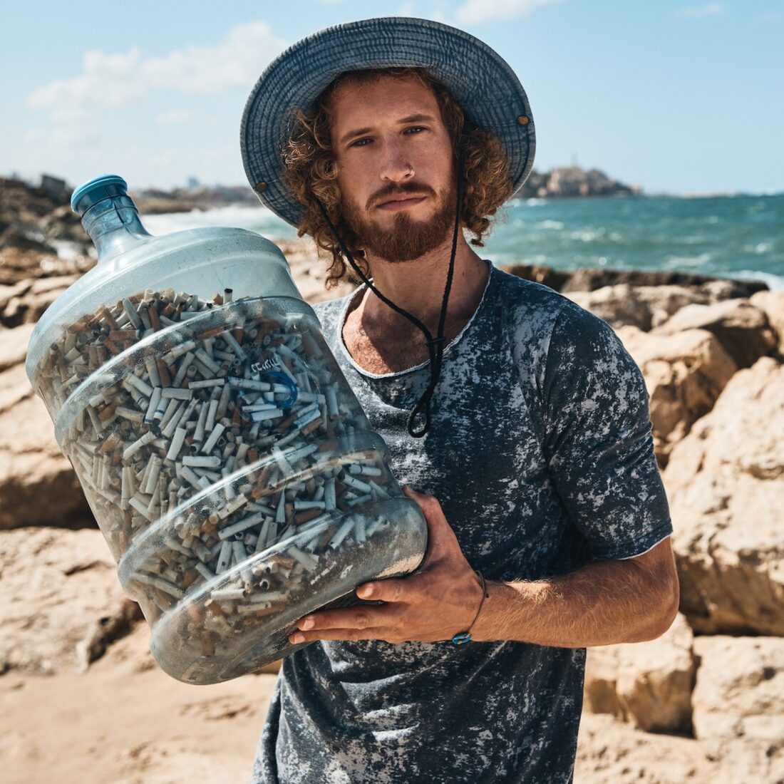 Julian Melcer with cigarette butts collected from Israel’s parks and beaches. Photo by Yossi Michaeli