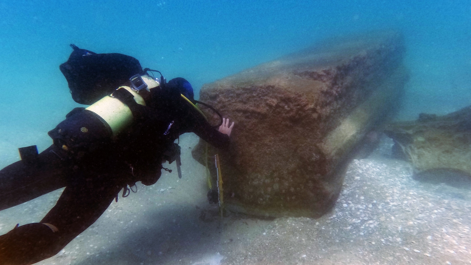 Diver examining a column from a 44-ton cargo of ancient artifacts found in the Eastern Mediterranean. Photo by the Theft Prevention Unit in the Israel Antiquities Authority