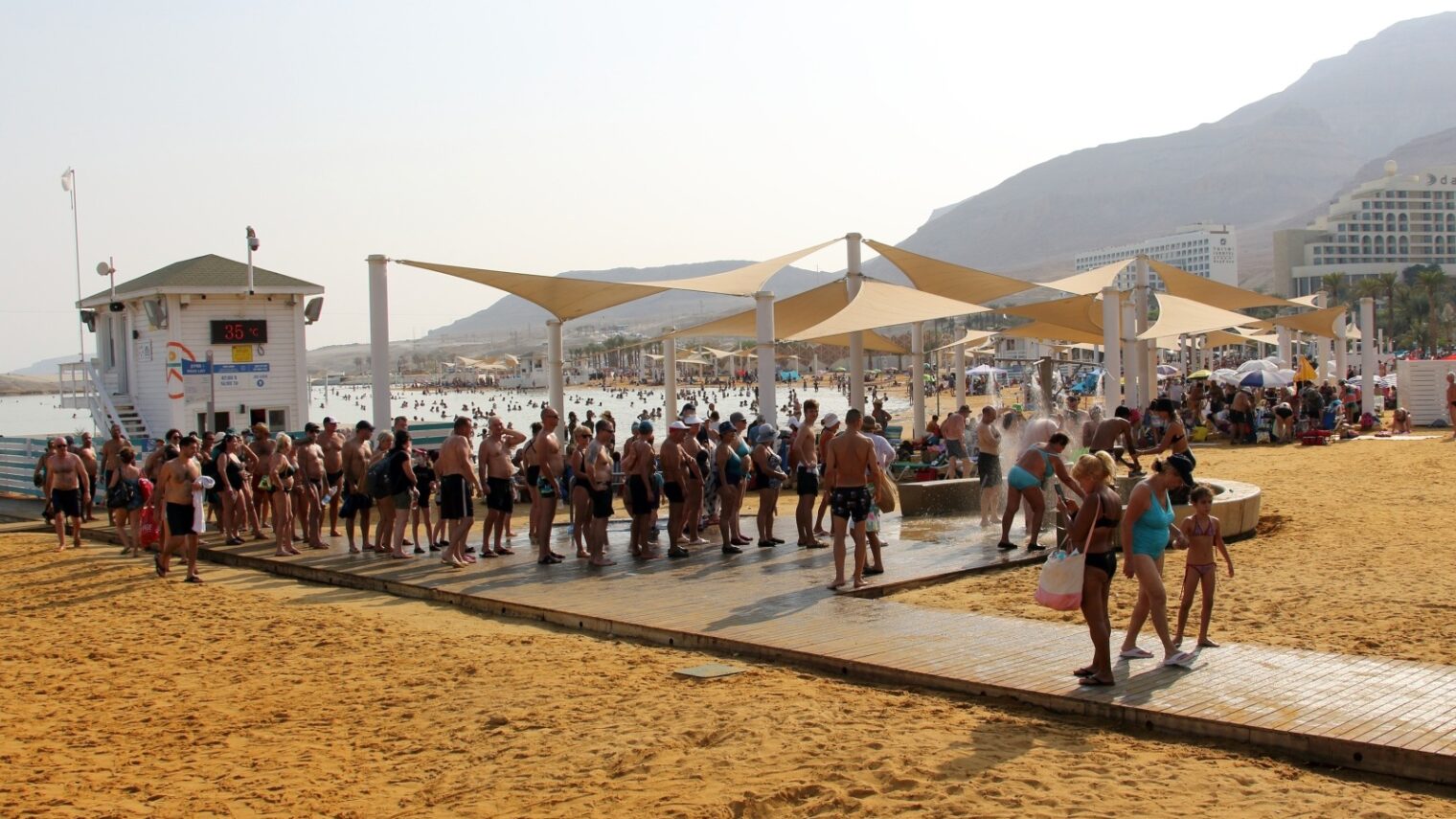 Bathers queuing up for the showers at an Ein Bokek (Dead Sea) beach. Photo by B-1972 via Shutterstock.com