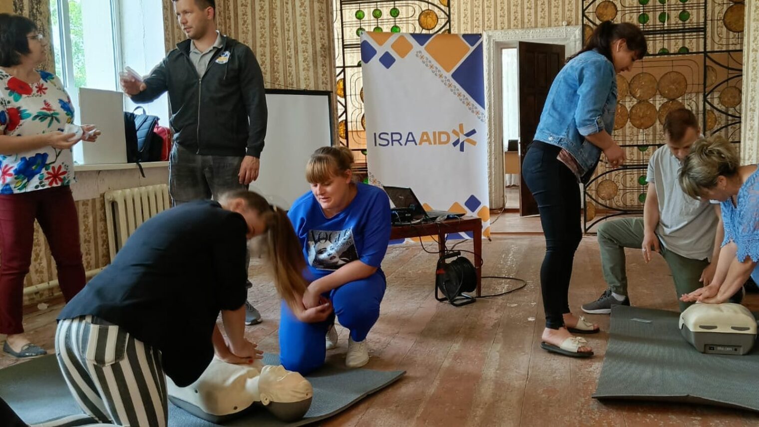 IsraAID staff train community members in Ukraine in first-aid techniques after the Nova Kakhovka dam burst. Photo courtesy of IsraAID