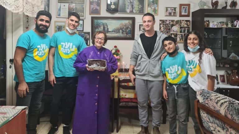 Israeli volunteers bring cakes to share with lonely elders