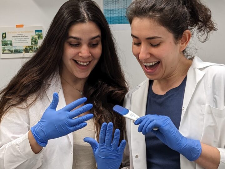 PhD student and study co-author Moran Rahamim, left, and Dr. Moriyah Naama with positive pregnancy tests they used in their experiments at Hebrew University-Hadassah Medical School. Photo by Dana Orzach