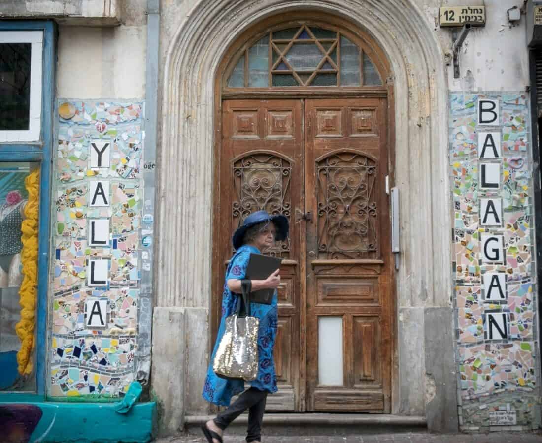 A woman walks by a street art mosaic on Nachalat Binyamin Street in Tel Aviv. Photo by Miriam Alster/FLASH90