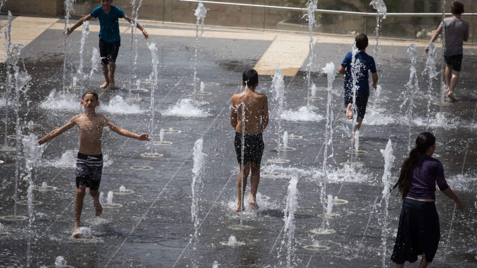 Children frolicking in Teddy Parkâ€™s sprinklers in Jerusalem. Photo by Hadas Parush/FLASH90