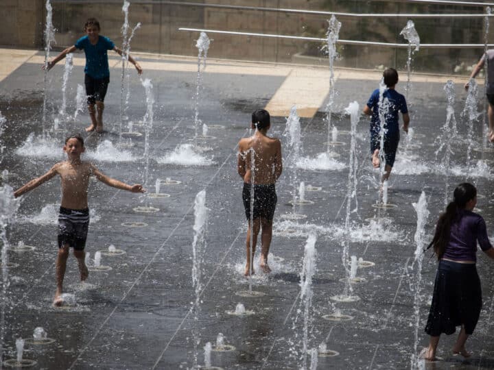 Children frolicking in Teddy Park’s sprinklers in Jerusalem. Photo by Hadas Parush/FLASH90
