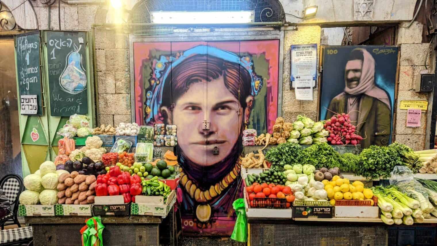 This market stall in Machane Yehuda’s Agas (Pear) Street got a centennial facelift with portraits of the original house’s owners, Bachora and Meir Banai. Photo by Solomon Souza